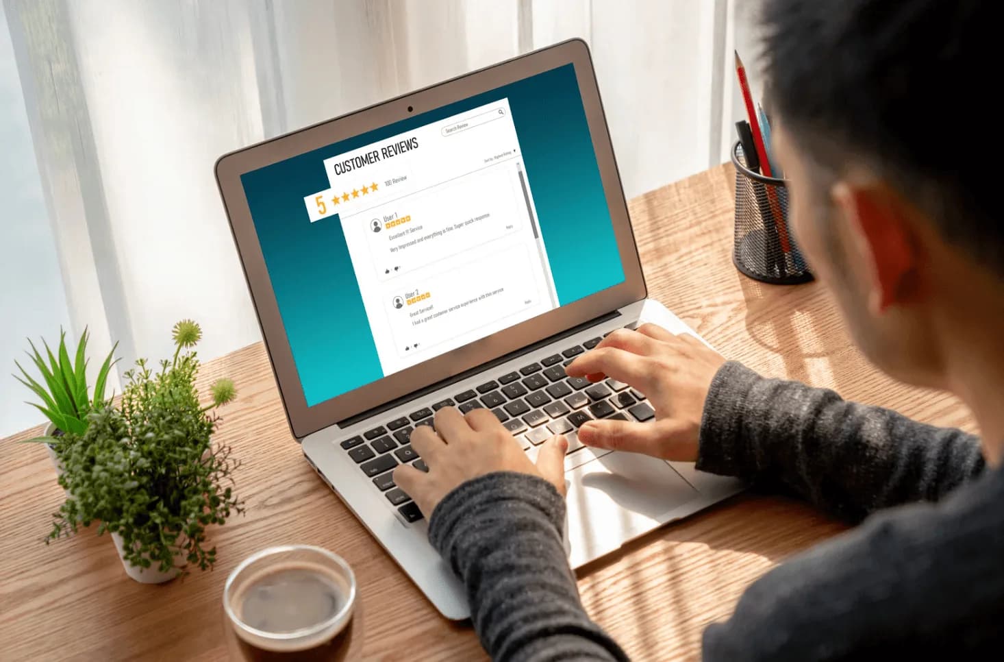 A person typing on a laptop with smiley face icons and five-star review graphics, symbolising reputation management.