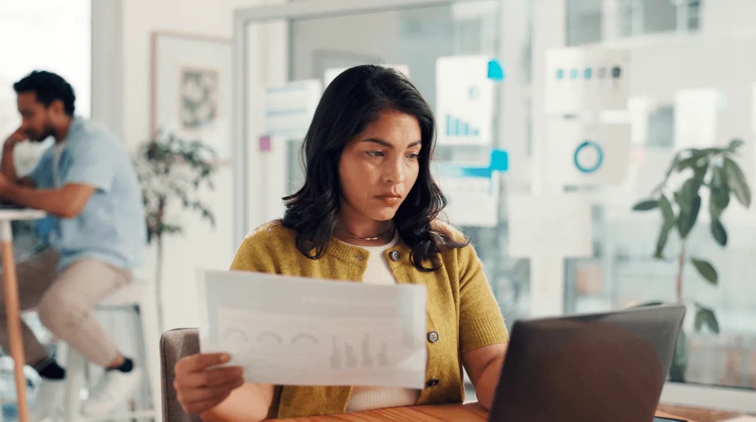 Woman analyzing marketing reports on a laptop, representing monitoring CPC changes and competitor activity in Amazon advertising auctions.