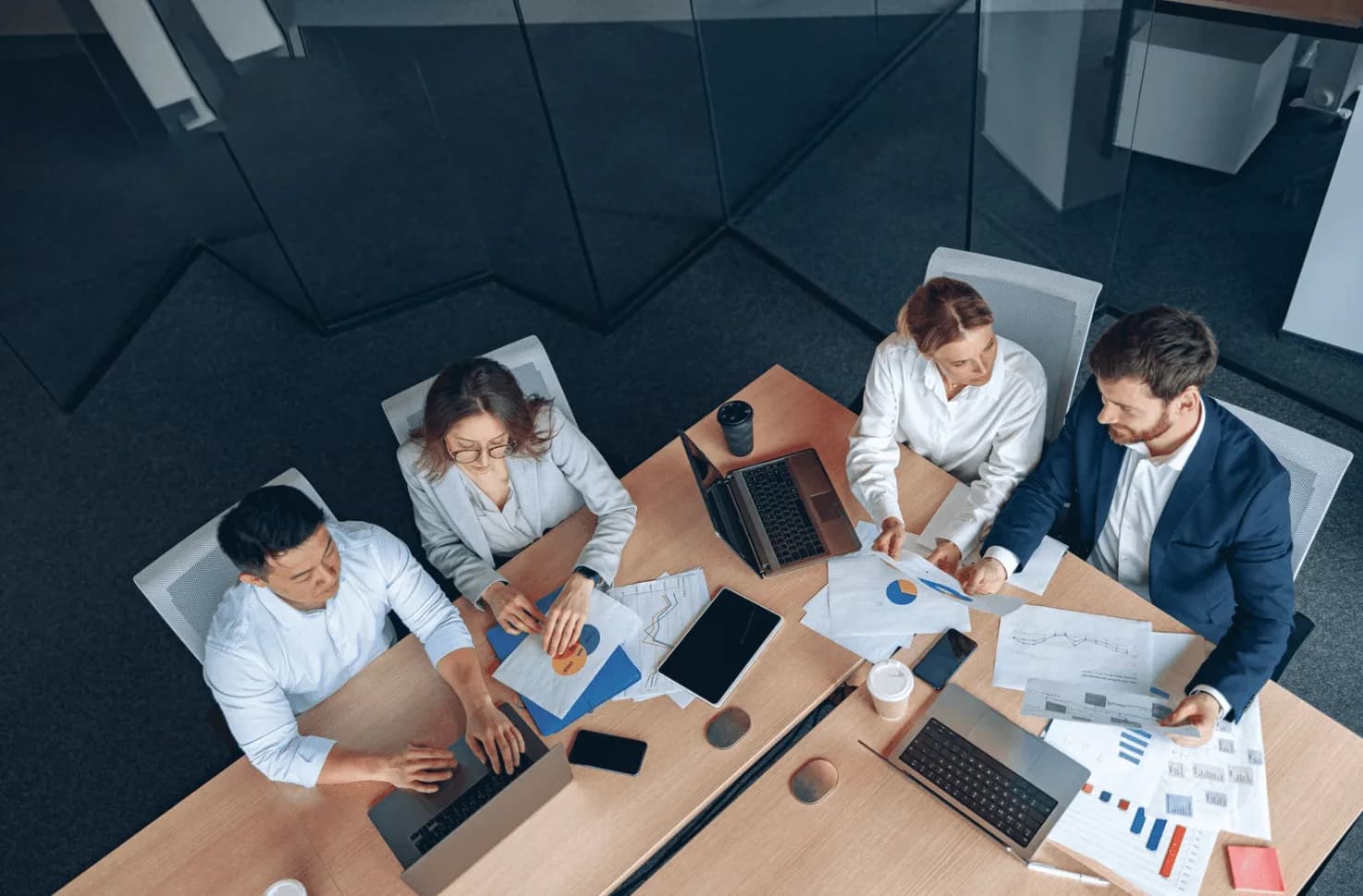 Team of professionals reviewing reports and data at a conference table, illustrating Autron’s AI-driven edge in Amazon Ads optimization.