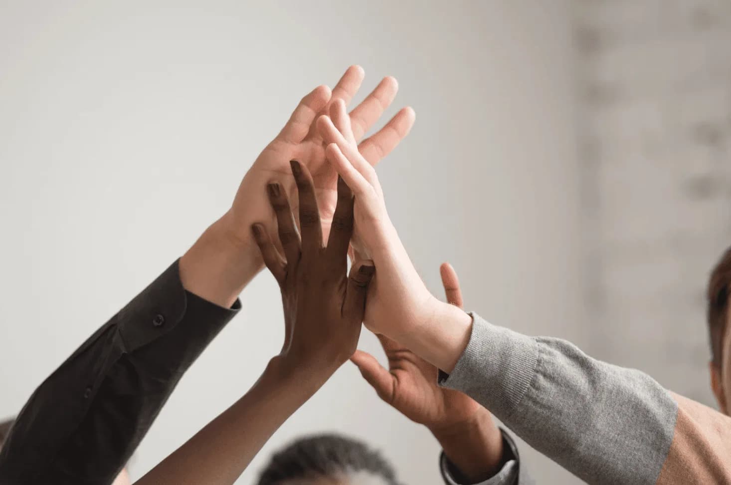 Diverse team giving a group high five, representing proactive Amazon Ads support and collaborative problem-solving before campaigns fail.