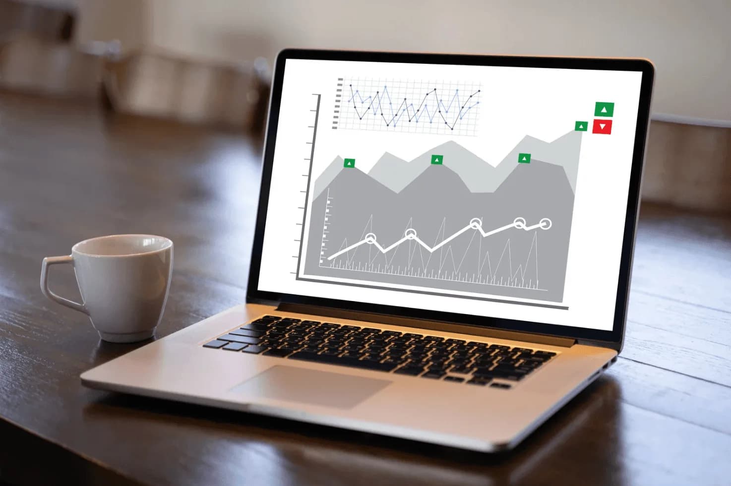 Laptop displaying performance analytics and trend graphs with a coffee cup beside it, representing custom dashboards and reporting for Amazon sellers.