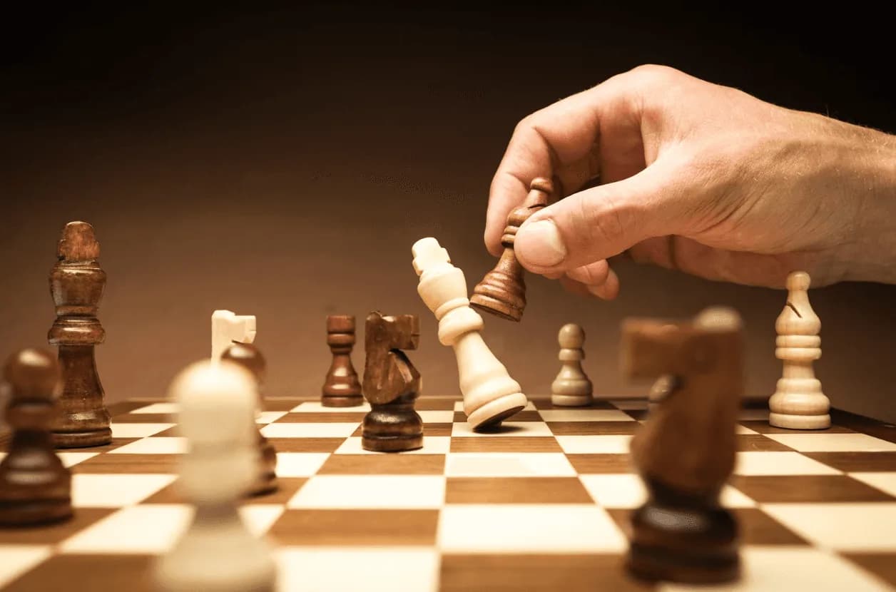 Close-up of a chess move with a king being captured — symbolising strategy, control, and preventing internal campaign competition in Amazon advertising.