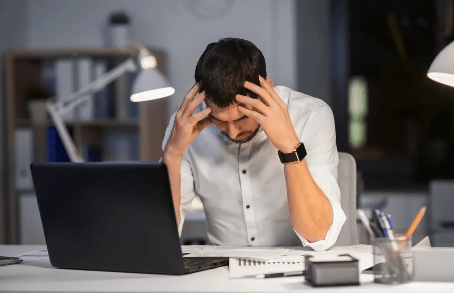 Stressed Amazon ads manager holding head in frustration at laptop—illustrating the danger of ignoring TACoS in campaign management.