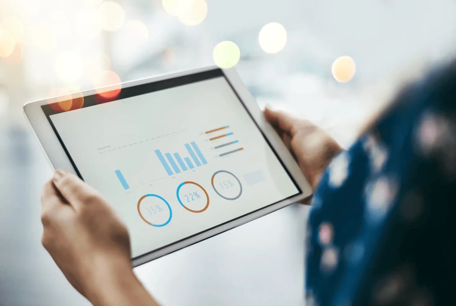 Person holding tablet with charts and graphs—illustrating the trap of chasing vanity metrics in Amazon advertising.