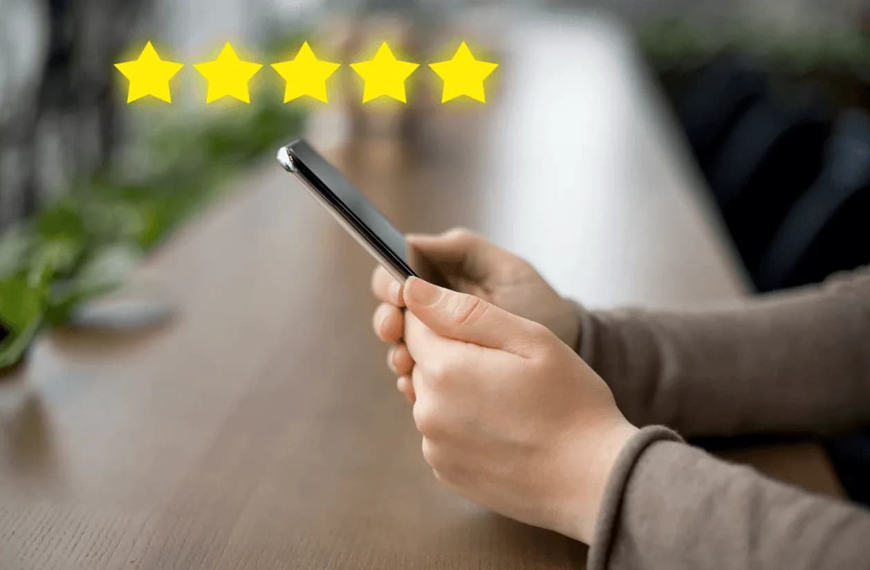 Person holding a phone with five-star rating overlay – symbolising review automation and its role in Amazon PPC success.