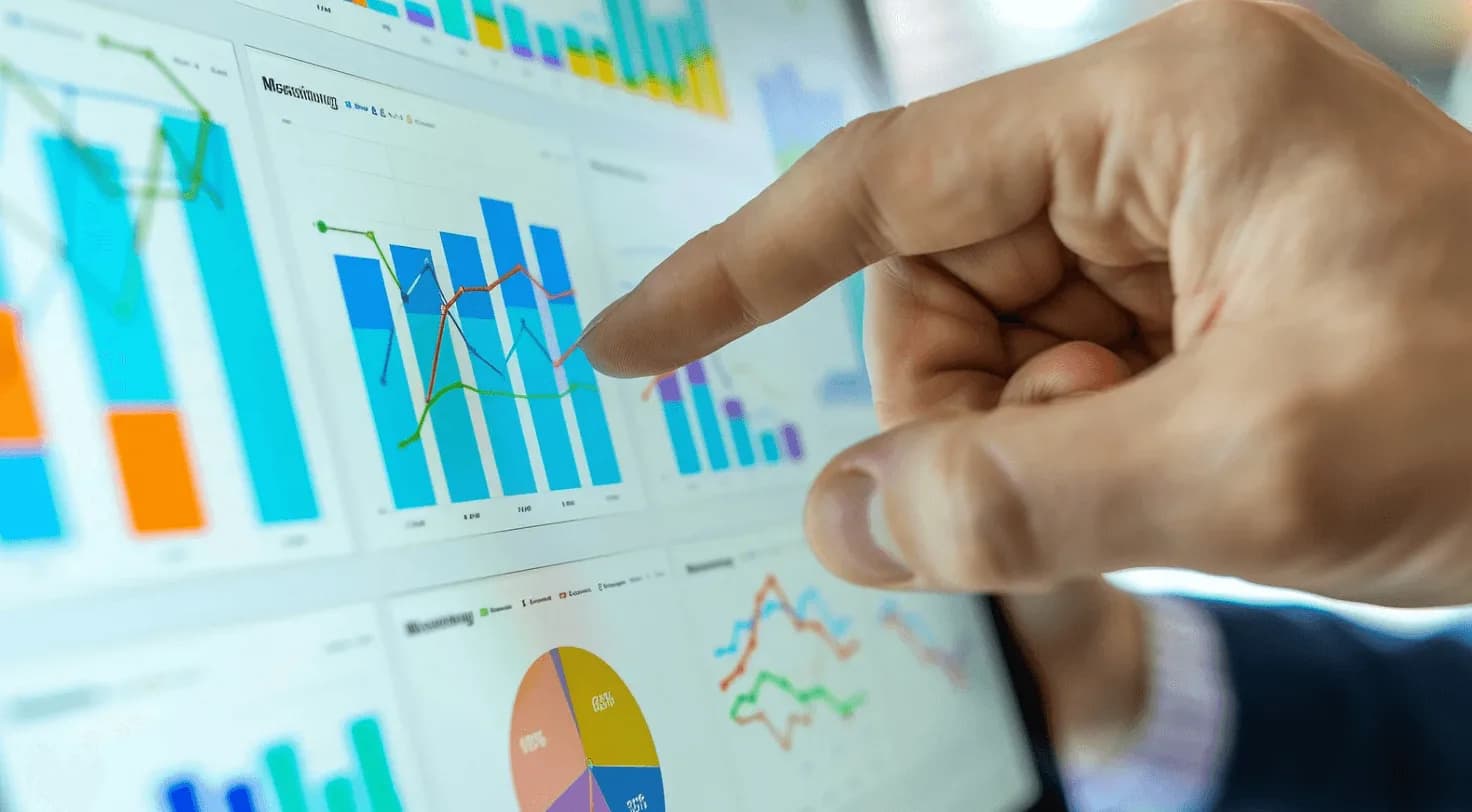 Hand pointing at digital dashboard with bar charts, line graphs, and pie charts representing real-time Amazon PPC auction data shifts.
