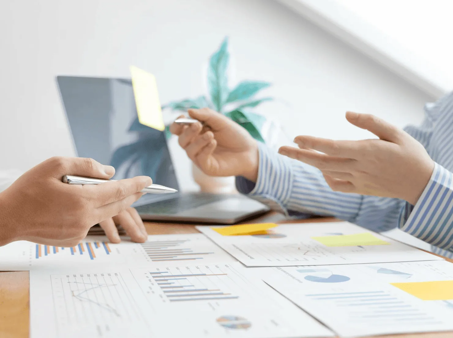 Hands discussing charts and KPIs to set Amazon PPC goals—sales, profit and visibility—guided by real-time insights.