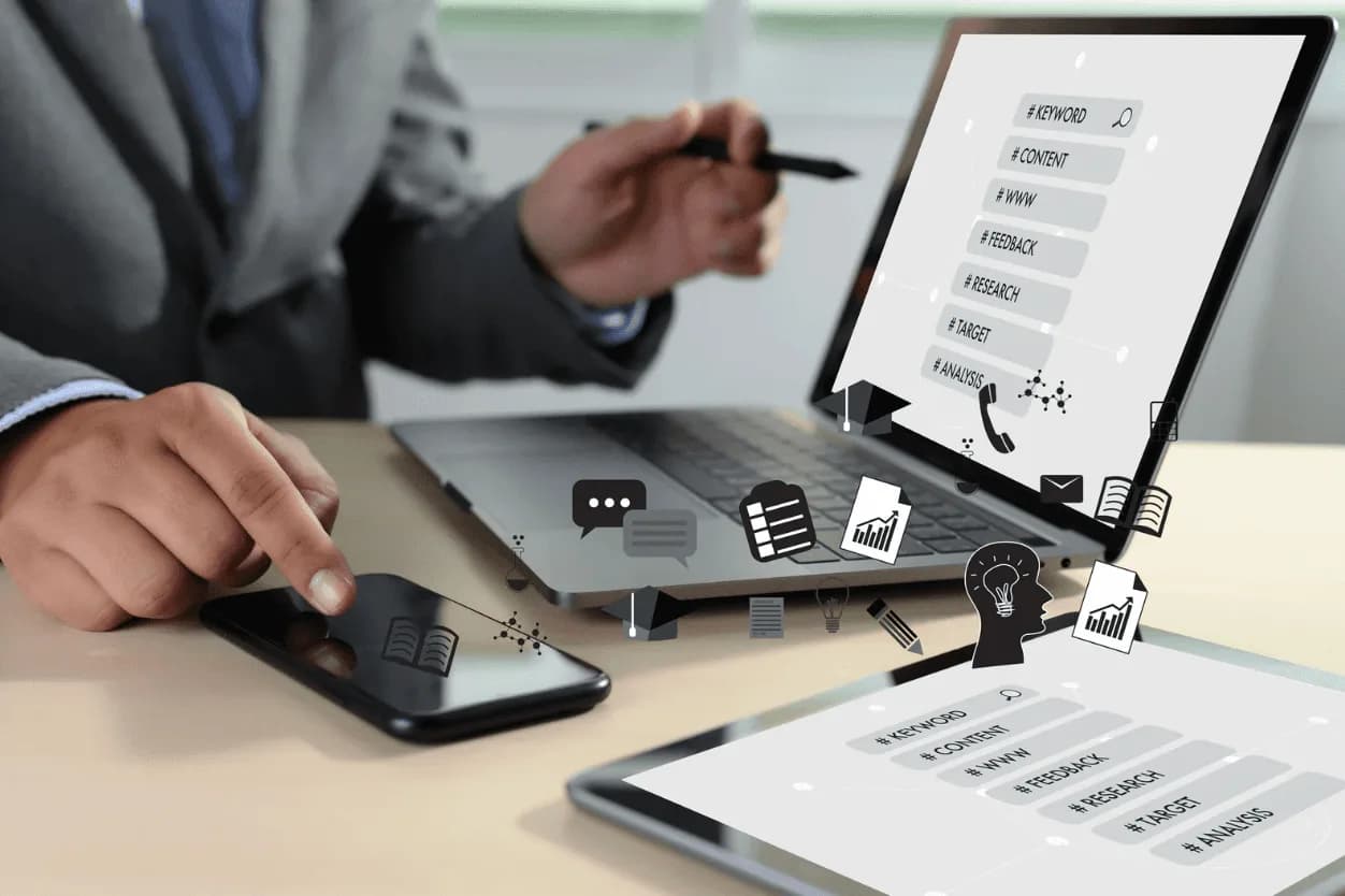 Professional tapping a smartphone beside a laptop displaying icons for keyword research, content, feedback, targeting, and analysis, illustrating advanced Amazon SKU management strategies.