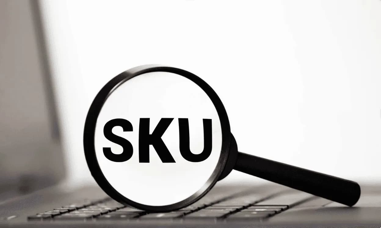 Magnifying glass focusing on the word “SKU” on a laptop keyboard, symbolizing Amazon SKU optimization for portfolio growth.
