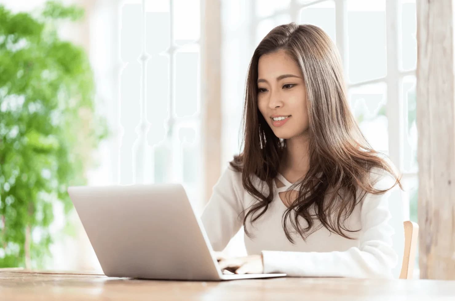 Smiling woman using a laptop in a bright room, symbolising confident control and success with Autron’s Turbo Mode.