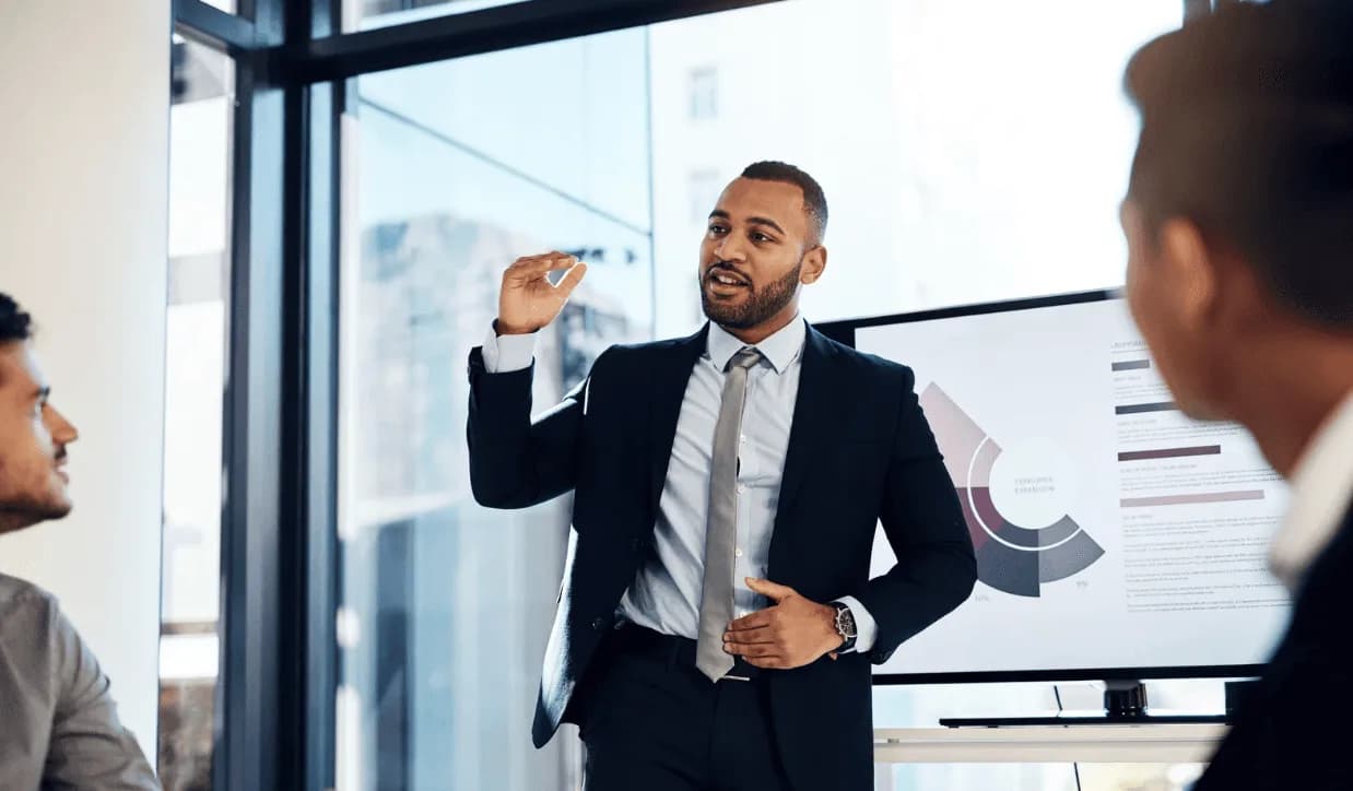Business professional presenting marketing strategy to colleagues with data visualisation on screen