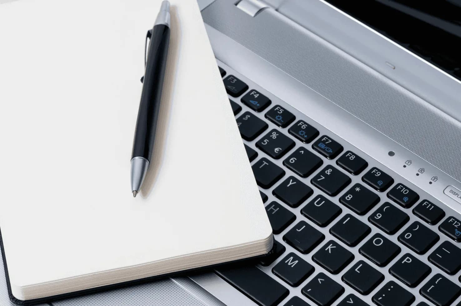 Amazon seller planning post-holiday ad strategy adjustments with laptop and notebook for Q1 campaign optimization