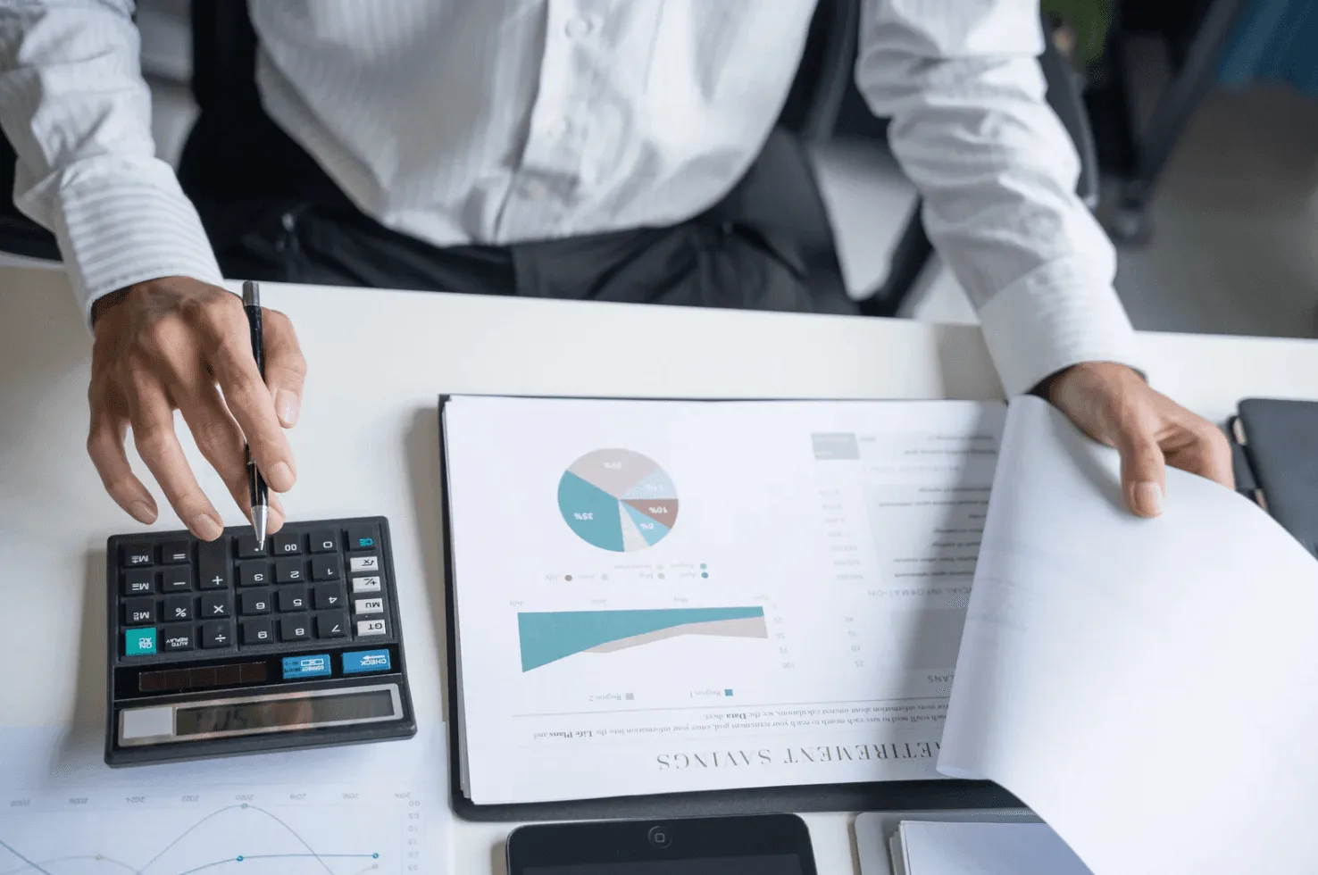 Person reviewing analytics reports with a calculator, representing cross-ASIN inefficiencies and wasted spend that Amazon ad services often miss.