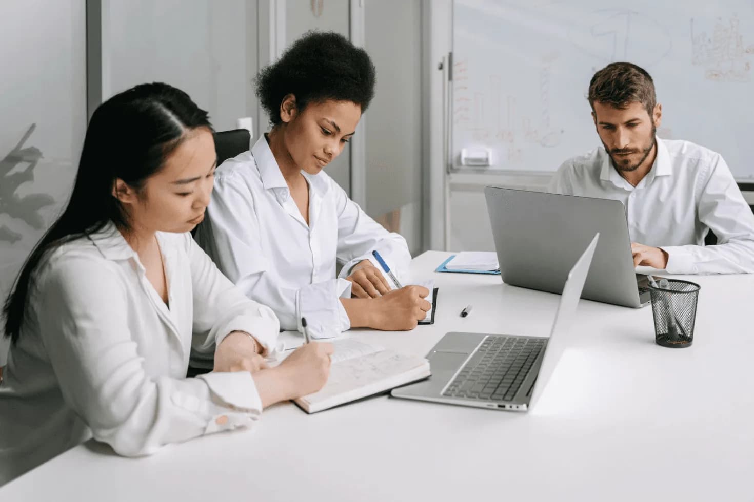 Team working at a conference table with laptops and notes, highlighting the complexity of managing hundreds of Amazon PPC campaigns at scale.