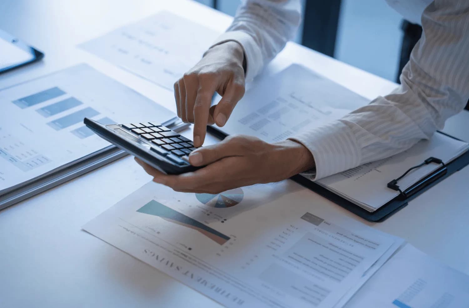 Professional reviewing marketing data and calculating metrics, symbolizing goal setting and campaign restructuring for seasonal Amazon PPC strategy.