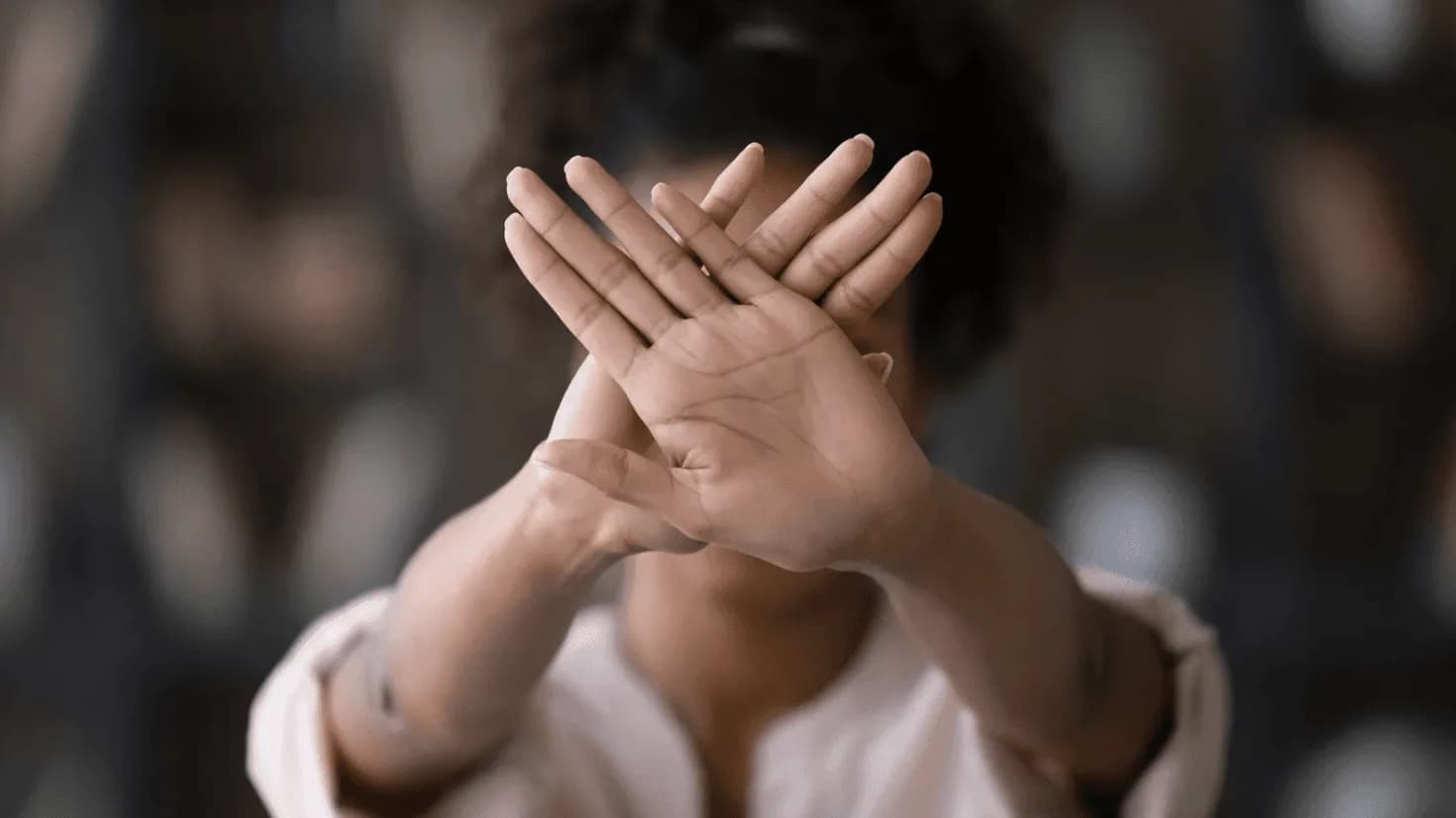 Person holding crossed hands in front of face as a stop gesture, symbolising breaking away from outdated Amazon PPC habits and embracing automated, efficient ad management systems to prevent wasted spend.