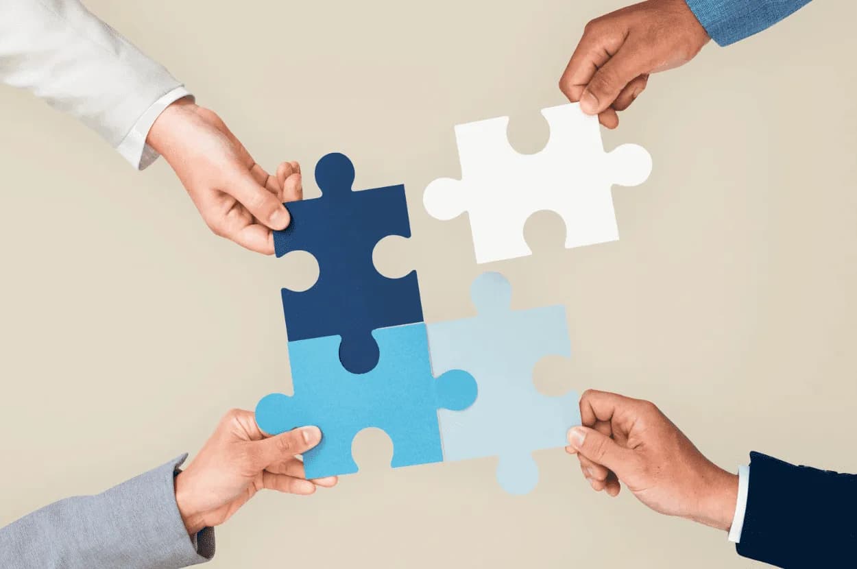 Hands holding interlocking puzzle pieces representing data integration and strategic alignment