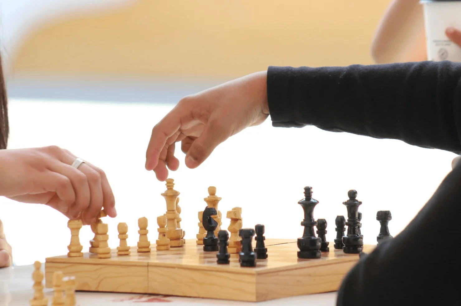 Hands moving chess pieces — illustrating that smart strategy alone isn’t enough without consistent execution at scale.